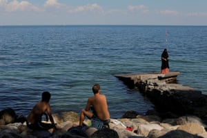 Swimmers watch on as Anna-Bella, 26, who was born in Peru and converted to Islam at age 20, walks along the seafront in Copenhagen.