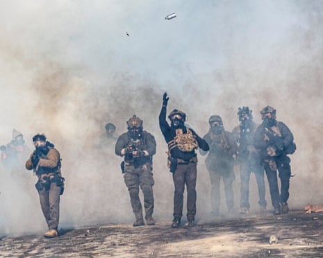 A federal agent lobs a teargas canister towards protesters as agents advance during clashes following the fatal shooting of Alex Pretti earlier in the day in Minneapolis