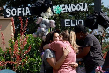 Mourners embrace at a memorial set up near the scene of the mass shooting at the Allen Premium Outlets mall in Allen, Texas. 