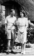 King George VI, in shorts and knee socks and holding a pipe, standing next to the then Princess Elizabeth in South Africa in 1947