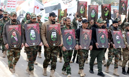 Members of the Iraqi Shia Popular Mobilisation Forces (PMF) at a funeral procession in Baghdad in February, carrying images of their comrades killed in US airstrikes.