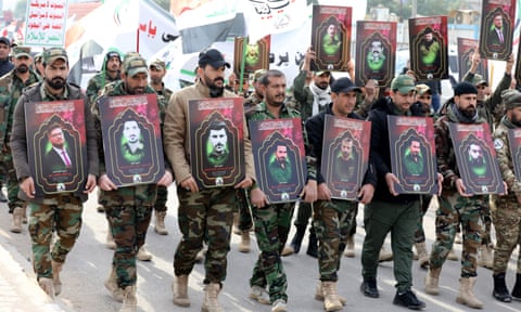 Members of the Iraqi Shia Popular Mobilisation Forces (PMF) at a funeral procession in Baghdad in February, carrying images of their comrades killed in US airstrikes.