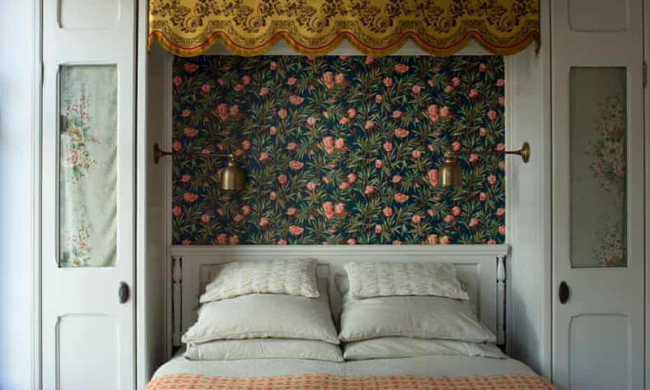 Bedroom with decorative wallpaper behind the bed