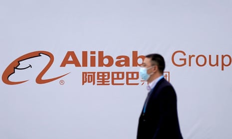 Man walks past Alibaba logo