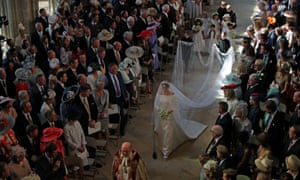 Pageboys carry Markle’s veil as she walks down the aisle.