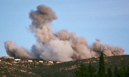 Smoke billows over a hilltop village