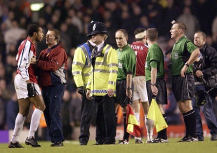 Thierry Henry is restrained as he argues with referee Graham Poll after Arsenal are beaten by Newcastle at home in December 2001.