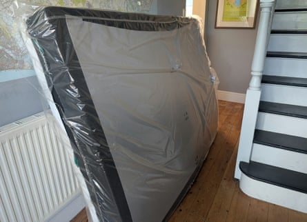 The Tempur Pro Plus SmartCool mattress in its plastic packaging in the reviewer’s hallway.