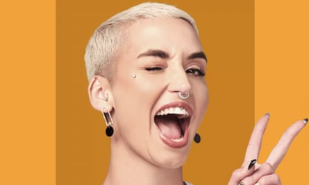 A cool-looking young woman with close-cropped blonde hair winks and smiles while giving the peace sign