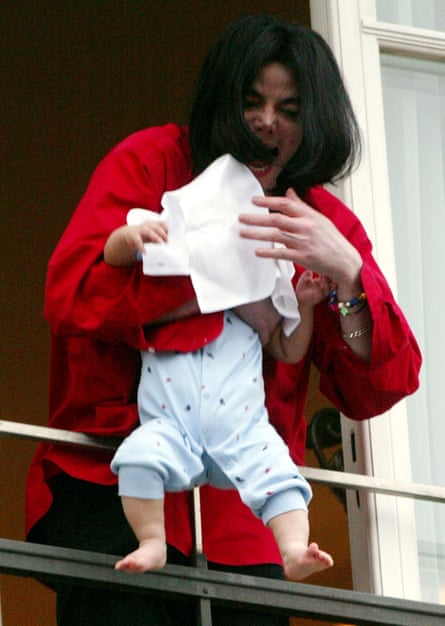 Singer Michael Jackson dangles his baby son off the balcony of a Berlin hotel room, November 19, 2002
