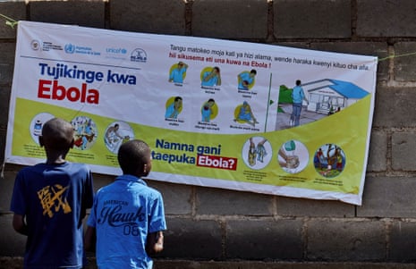 Children read a poster showing information out the Ebola outbreak.