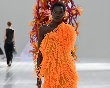 Model wears embellished orange gown