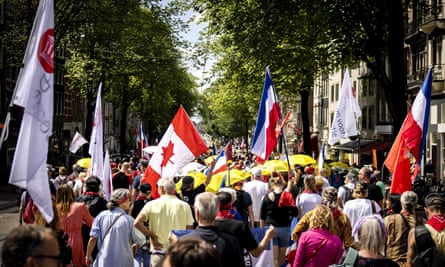 Les manifestants portent des drapeaux néerlandais et canadiens lors d'un rassemblement pour soutenir les agriculteurs, les pêcheurs et les camionneurs à Amsterdam en juillet.