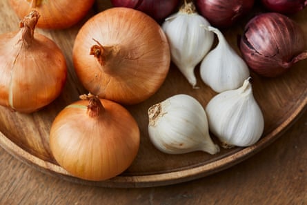 Garlic, onion and Spanish red onion on a wooden plateGarlic, onion and Spanish onion on a wooden plate, on a wooden kitchen table top