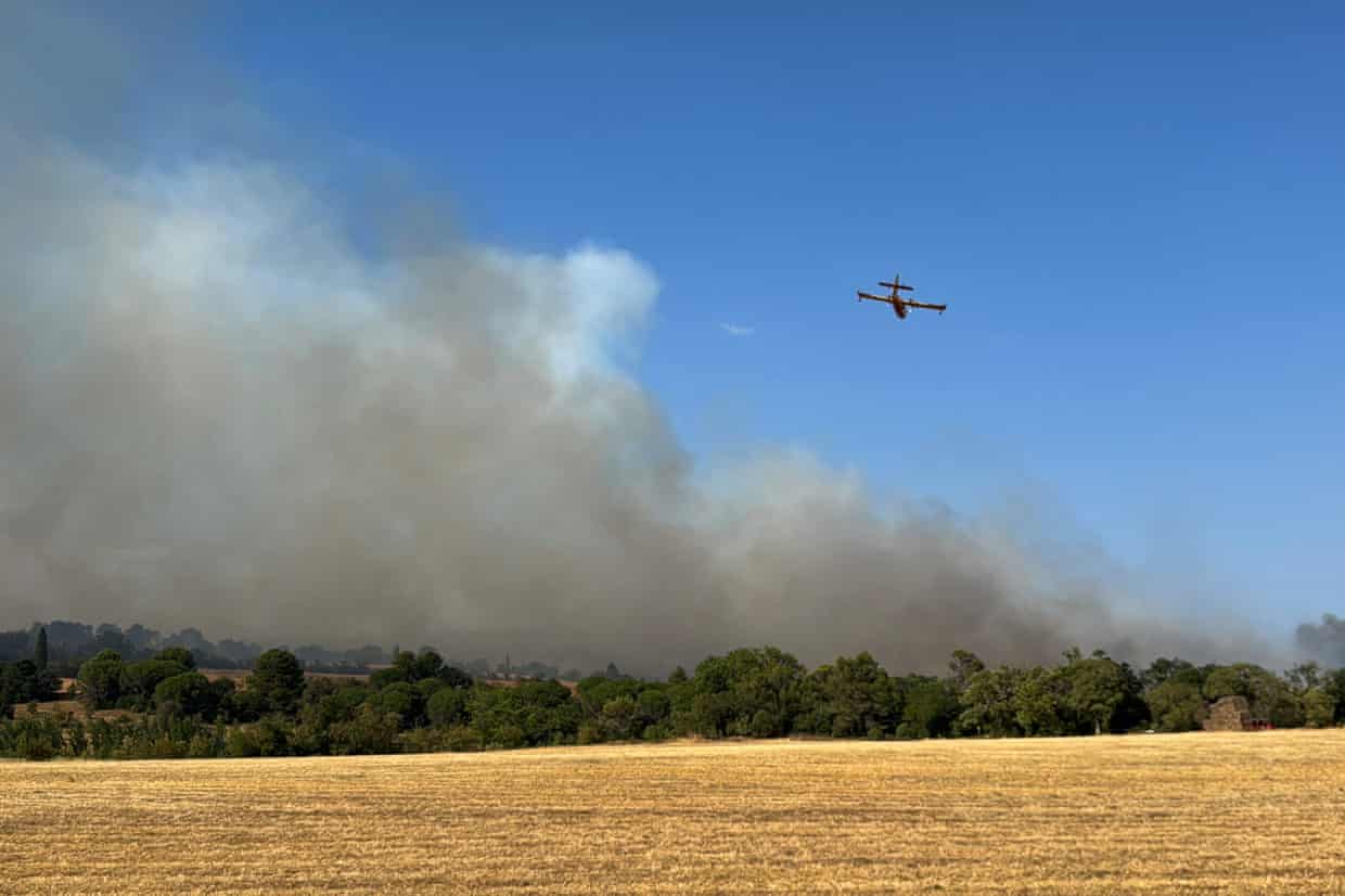 A Canadair CL-415 aircraft flies over a fire near Carcassonne, southern France