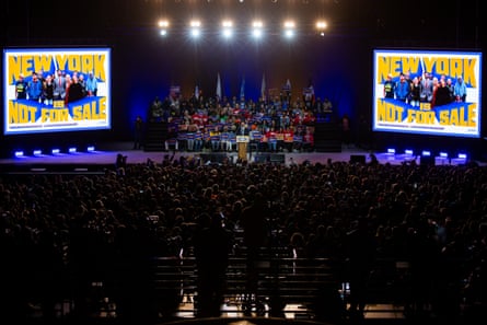 wide view of a man speaking into a microphone to an arena full of people