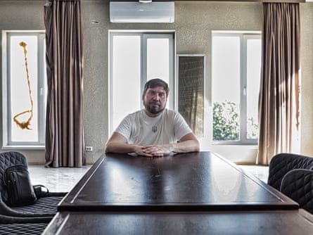 A man sitting at a long table in a hotel room.