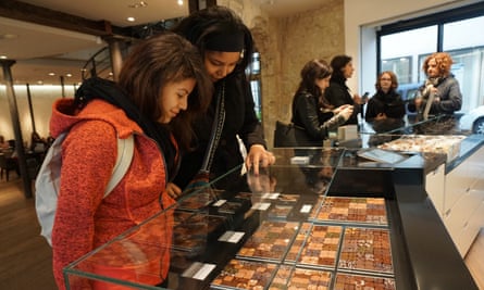 Context Travel. New Parisian Palate: Modern Tastes of the Marais. Two young women look down into a glass cabinet full of artisan chocolates.