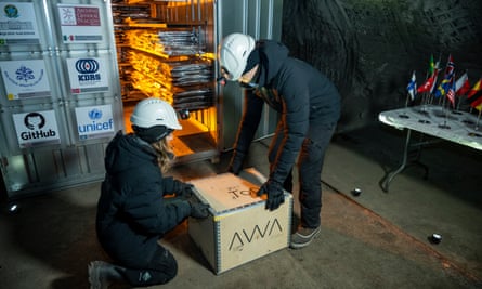Staff in protective headgear at the Arctic World Archive unloading a box from a storage facility