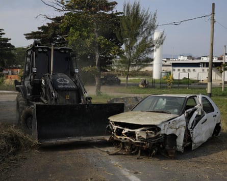A digger destroying a car as part of a police drill.