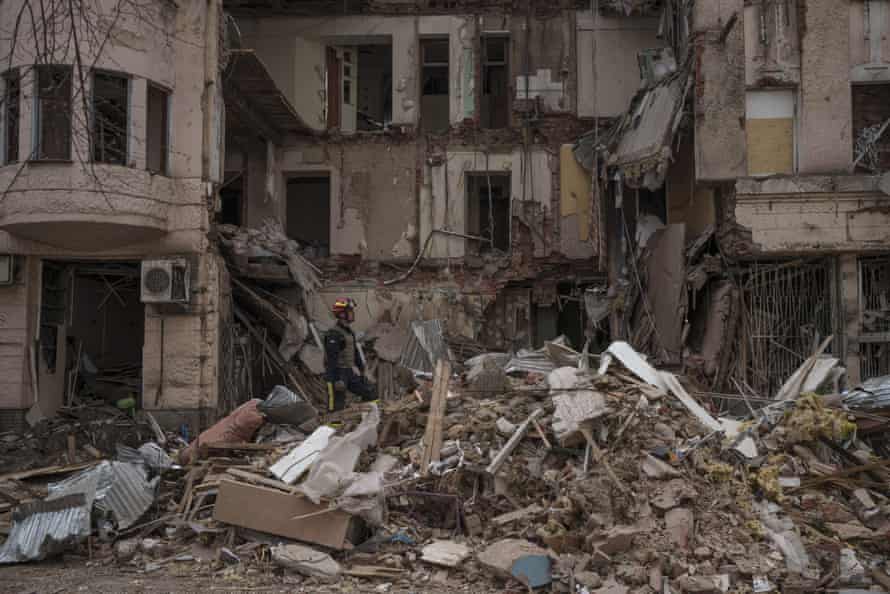 Firefighters clear the debris and search for bodies under the rubble of a building hit by a Russian attack in Kharkiv, Ukraine.