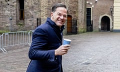 Mark Rutte walks across a cobbled street holding a coffee cup