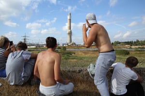 Isle of Grain, England: A man covers his ears as the noise reaches locals gathered to watch as Grain A power chimney is demolished