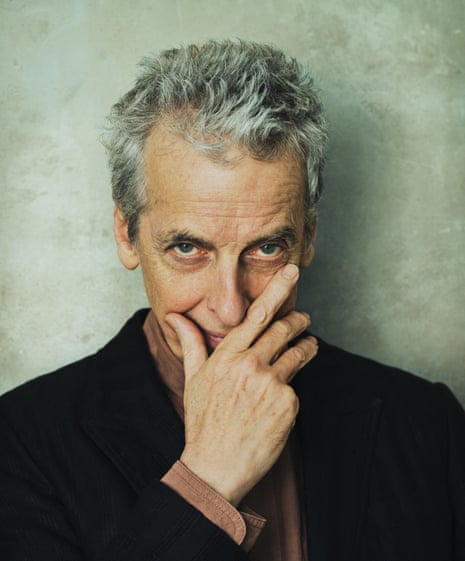 Peter Capaldi, head and shoulder shot, holding his hand to his mouth and looking up; wearing a black jacket and brown shirt