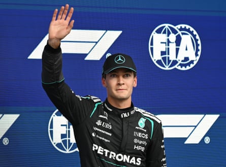 George Russell waves to the fans after taking pole
