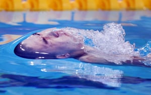 A close-up of a swimmer about to emerge from the water during a race