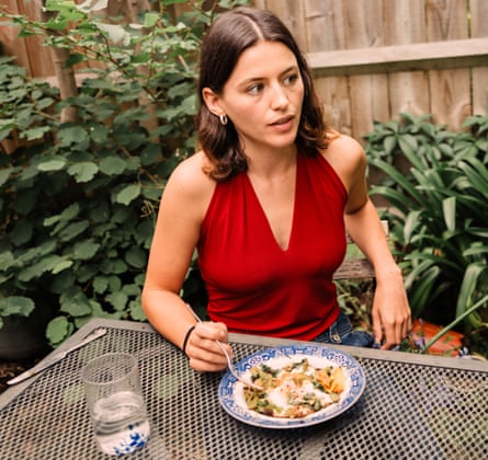 Chiara Wilkinson eating a meal made out of leftovers in the garden of her shared flat.