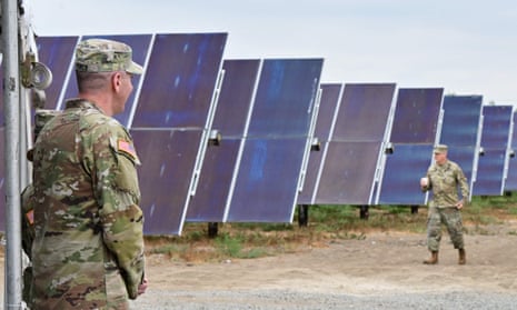 soldiers walking past solar panels