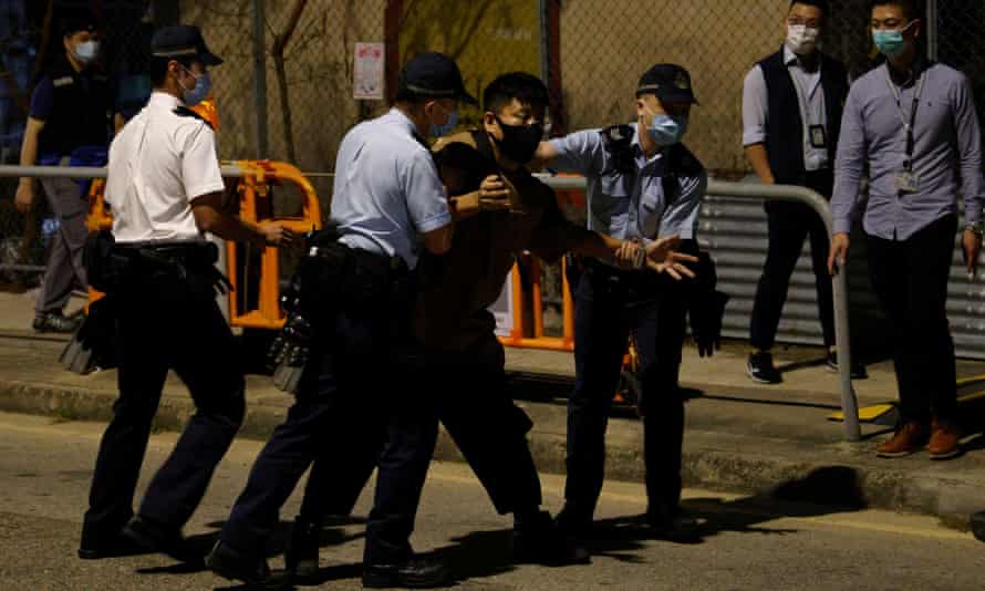 An animal activist is detained by police as he tries to steer the wild boars away from the traps.