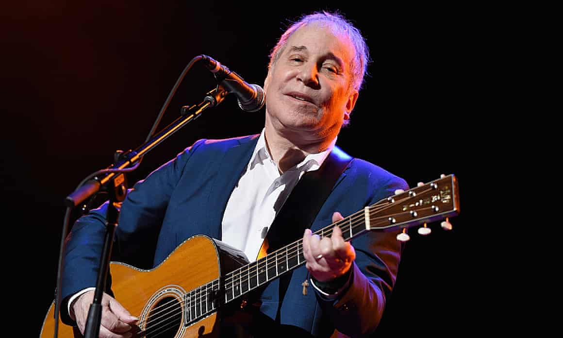 Paul Simon performing with guitar
