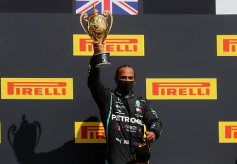 Hamilton celebrates on the podium with the trophy.