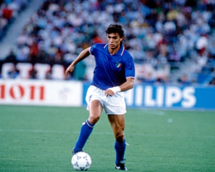 football player in a blue and white kit with a football in a stadium