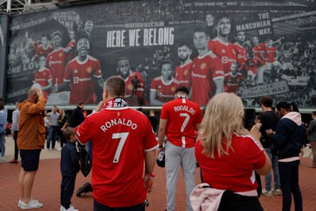 Les fans se rassemblent devant l'énorme bannière sur le devant d'Old Trafford