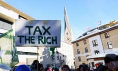 Demonstrators hold a homemade sign saying Tax the Rich in downtown Davos, Switzerland, on January 14.