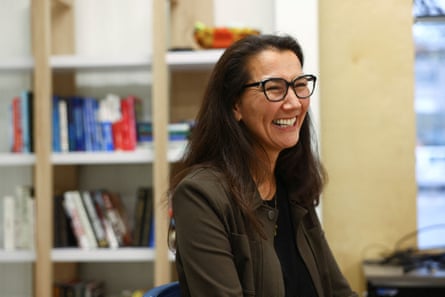 Smiling woman in office with bookcases.