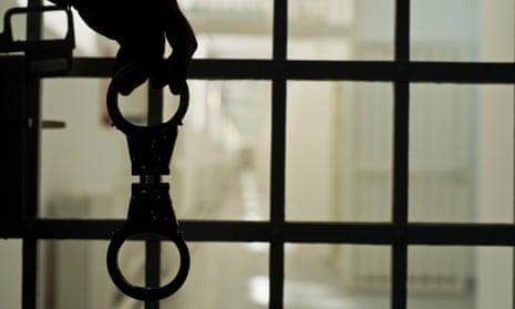 Close up of silhouette of handcuffs and prison bars of jail cell