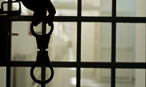 Close up of silhouette of handcuffs and prison bars of jail cell