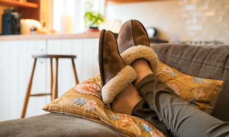 Close-up of a woman's feet in cosy slippers as she relaxes on the sofa at home.