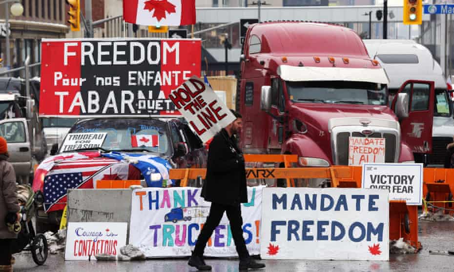 A protester walks in front of parked trucks as demonstrators continue to protest the vaccine mandates implemented by Prime Minister Justin Trudeau on 8 February 2022 in Ottawa, Canada. 