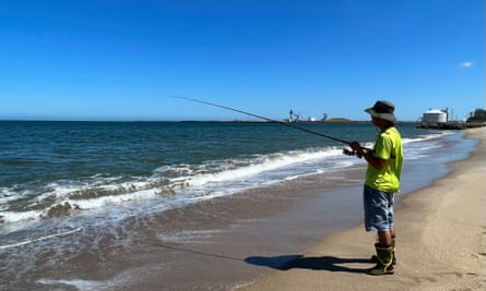 A man fishing on the coast.