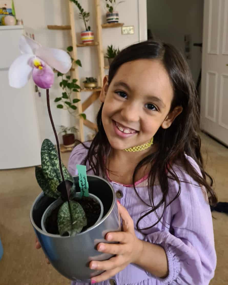 Inajara Schuaber’s daughter, with one of her orchids.