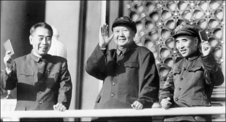 Mao Zedong with Zhou Enlai, left, and defence minister Lin Biao hold up Little Red Books as they review troops in Beijing in 1967.