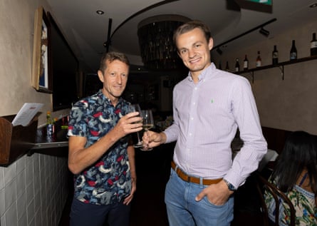 Tim and Lewis standing inside with drinks