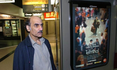 Mehran Karimi Nasseri passes by the poster of the movie inspired by his life in Terminal 1 of Paris’ Charles de Gaulle airport.