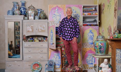Kaffe Fassett with the white cabinet he painted using acrylics and a little glaze to soften it.