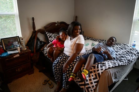 a mom and kids sitting on a bed